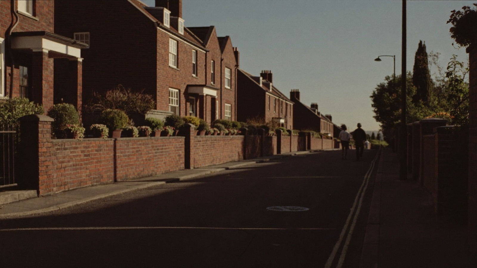 A terraced street at golden hour, two people walking together